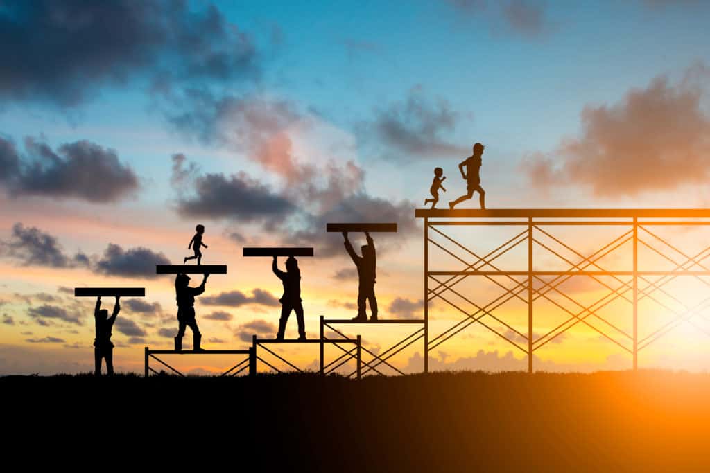 Silhouette graphic showing youngsters running to structure top supported by builders holding blocks